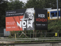 901966 Afbeelding van een groot reclamebord voor het woningbouwproject Now.nl, op het terrein van het gesloopte ...